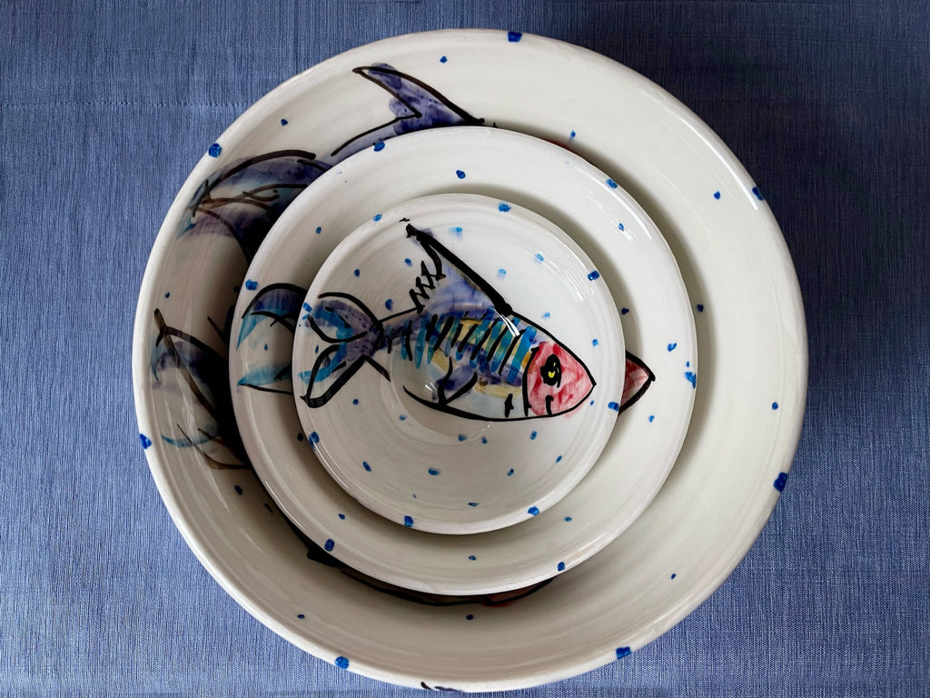 Beautifully presented handmade and hand painted ceramic pottery stacking bowls with fish design on white glaze and periodic blue dots