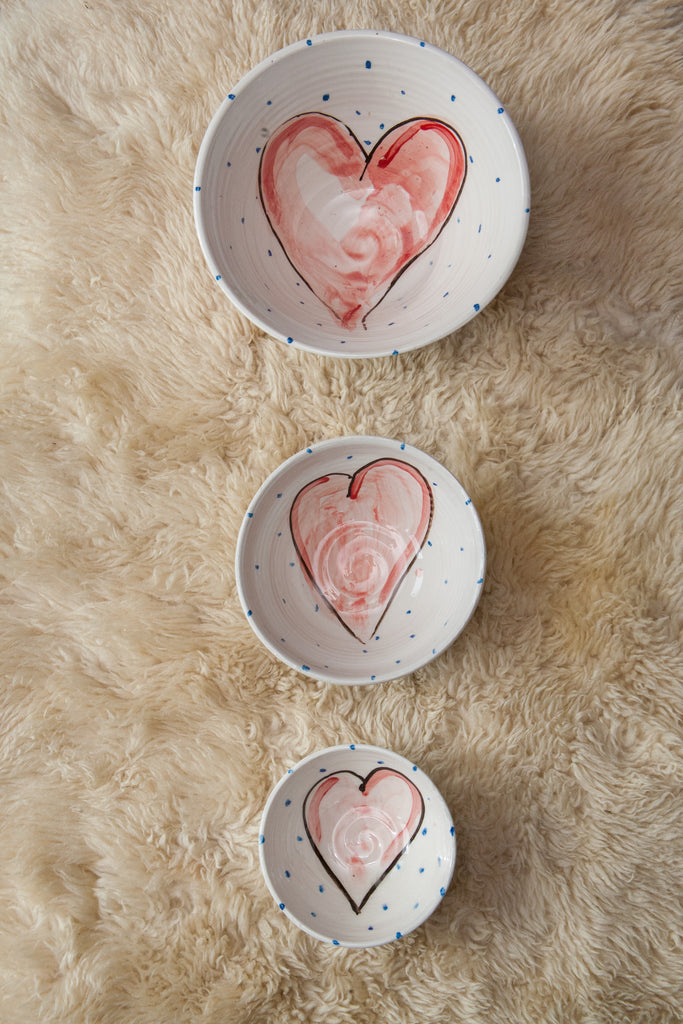 Three progressively larger bowls each with a hand painted red heart in the centre. It is the small, medium, and large bowl sizes of the Grá Heart collection. Handmade in Ireland.