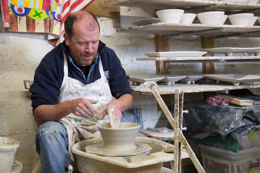 Charlie Mahon making bowls from clay on wheel in pottery studio