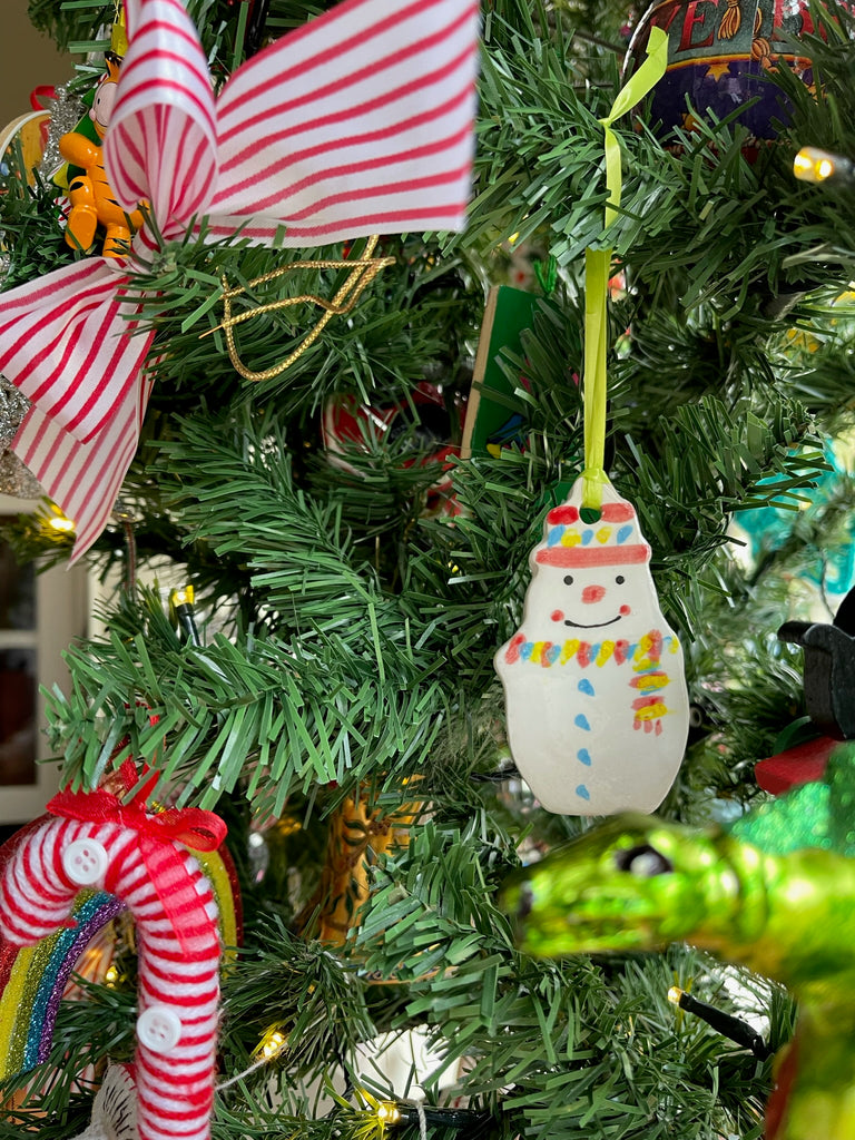 Snowman decoration hanging on a Christmas tree