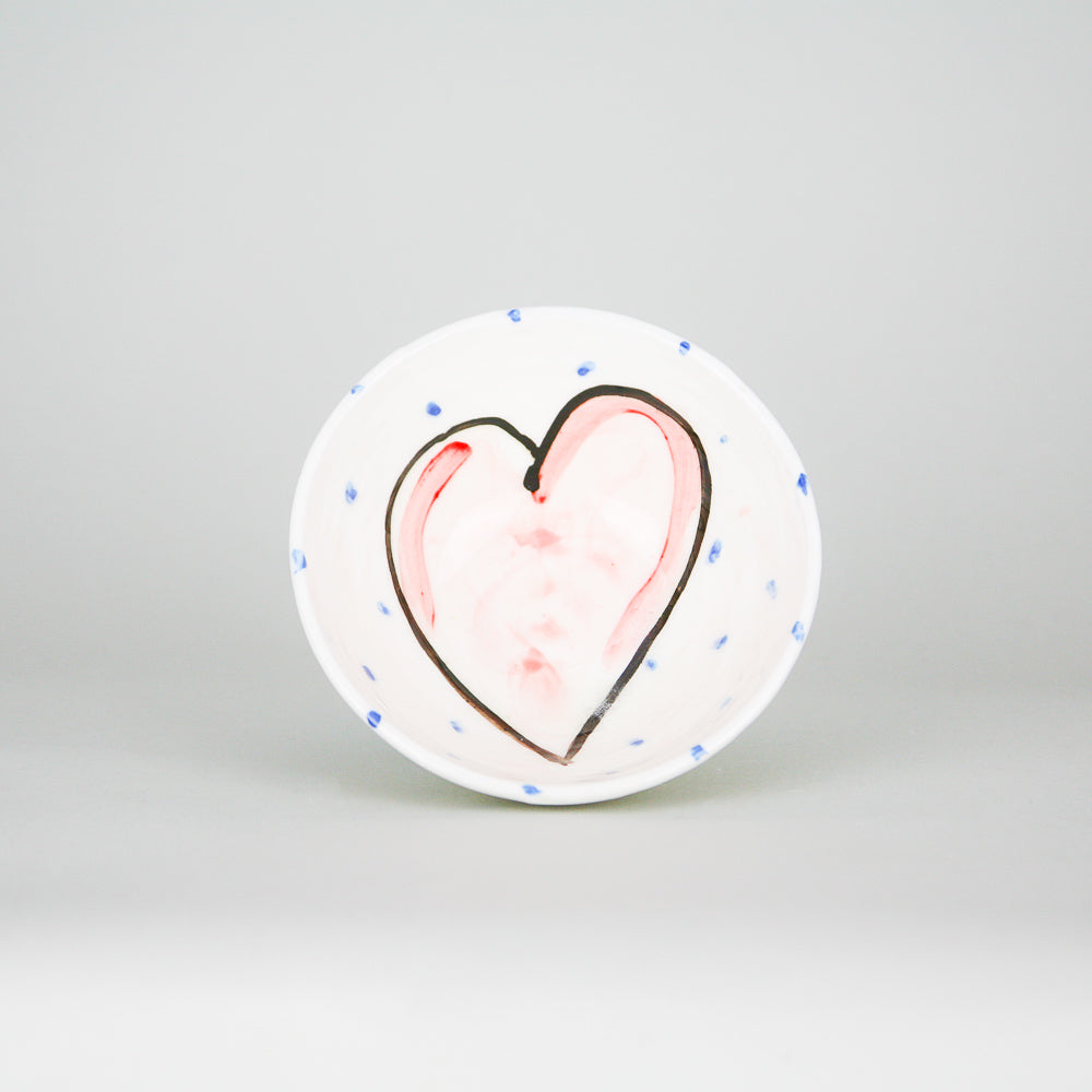 Small irish pottery dipping bowl / ramekin hand painted with a pink love heart with periodic blue dots on a luxurious white background