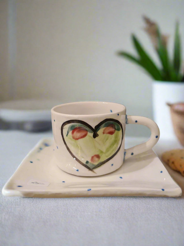 Gift SEt of a small ceramic mug and side plate, that can act as a saucer, hand painted with a beautiful fresh emerald green heart on white glaze and periodic blue dots.