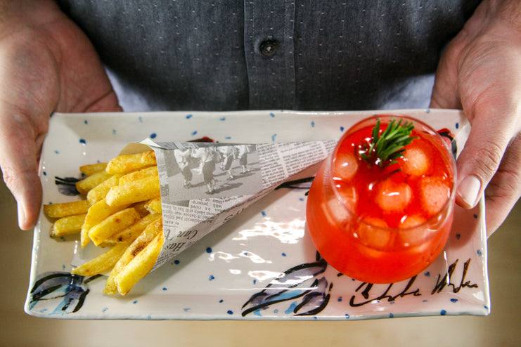 Handmade Irish rectangular serving platter, hand painted with traditional irish Mackerel Fish with periodic blue polka dots on luxurious white glaze. Seen here acting as a tray for a cocktail and side of chips!