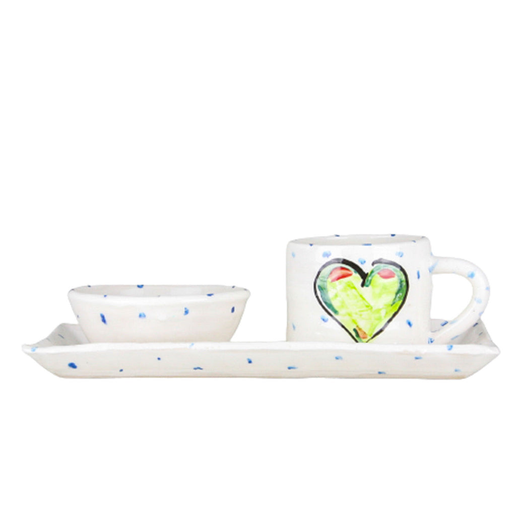 Green heart rectangular platter and mug set. The mug sitting on the right heart of the platter and handle facing right. Blue dots pepper the handmade Irish pottery. A ramekin bowl rests on the left side of the platter.