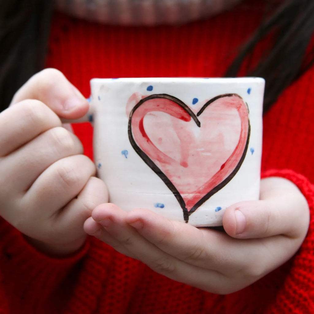 Love the Mug.  Our Gra Heart Mug is truly beautiful.  Handmade and hand painted with a delicate heart painted in pink on white glaze with periodic blue dots.