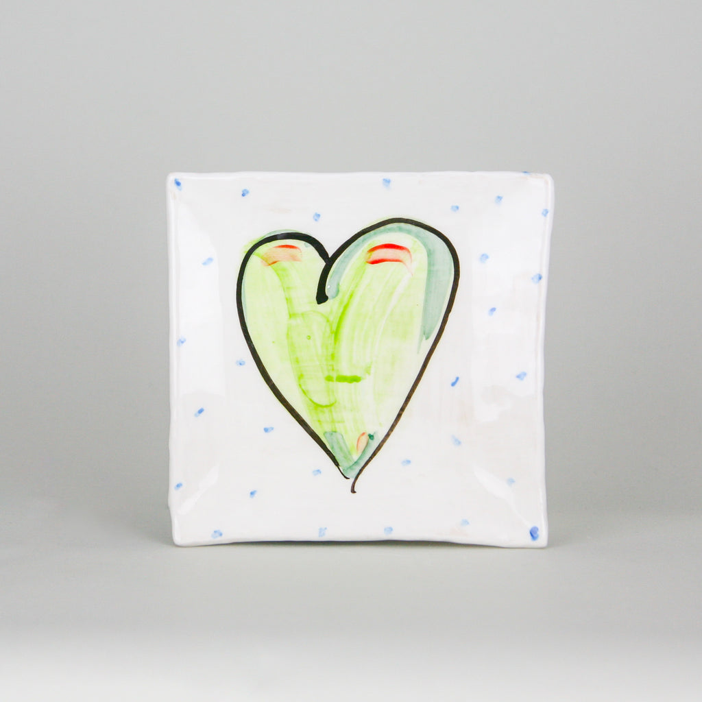 Small square plate handmade with white Irish ceramics pottery. Hand-painted with a green heart outlined in black and peppered with blue dots. Perfect size for toast, a sandwich, or dessert. Handmade in Ireland.