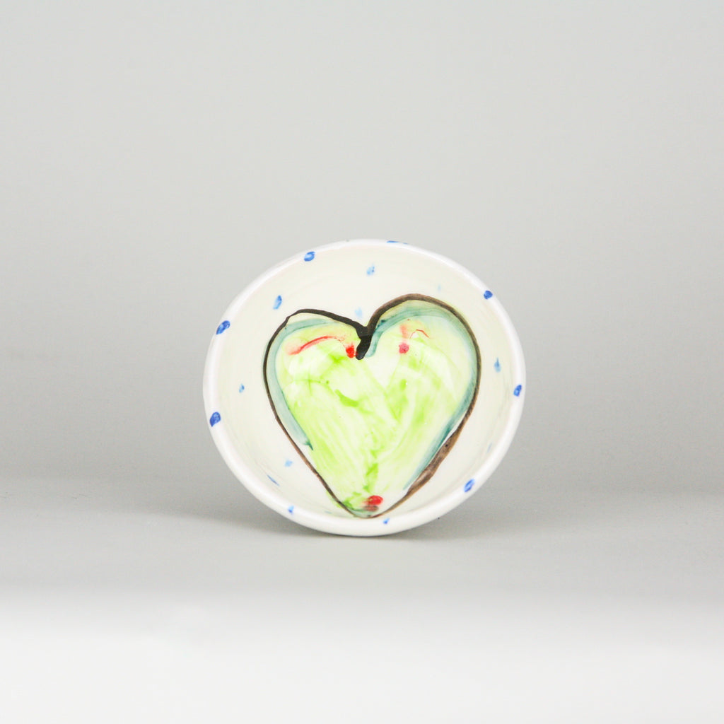 Green heart hand-painted on the inside of a ramekin bowl with blue dots peppering the white Irish ceramic pottery. Handmade in Ireland.