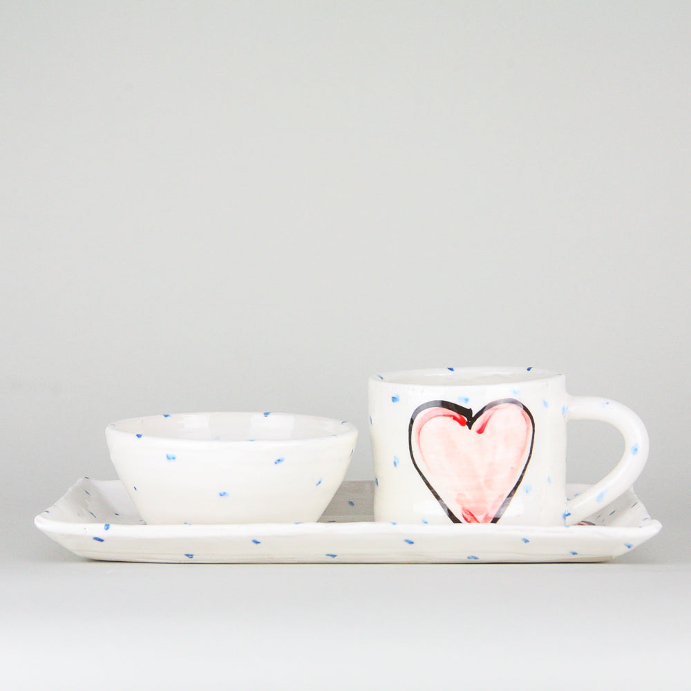Red Grá Heart rectangular platter and mug pottery gift set. The mug sitting on the right heart of the platter and handle facing right. Blue dots pepper the handmade Irish pottery. A coordinating ramekin bowl rests on the left side of the platter.