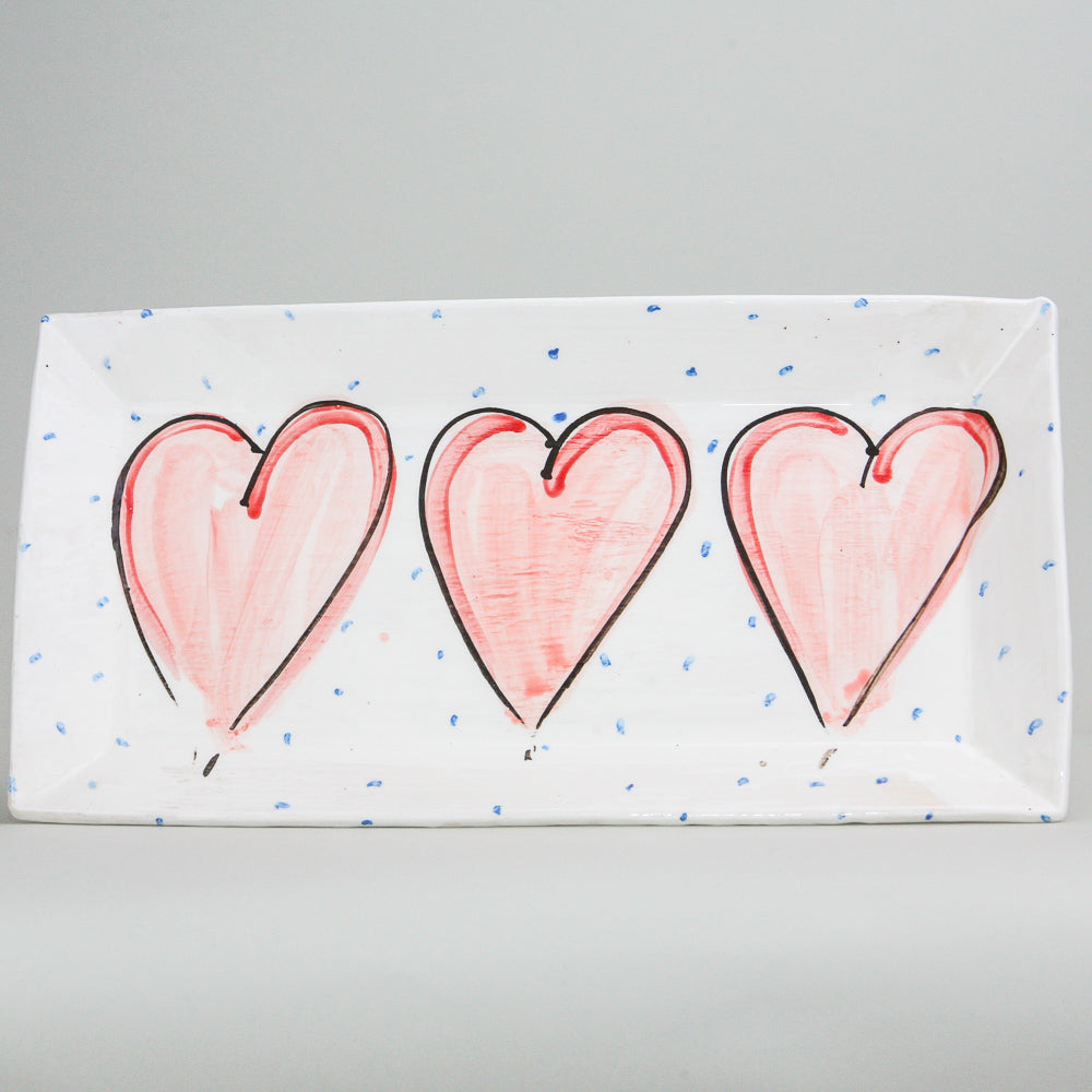 Rectangular platter. White pottery peppered with blue dots and hand-painted with red hearts. Handmade in Ireland.