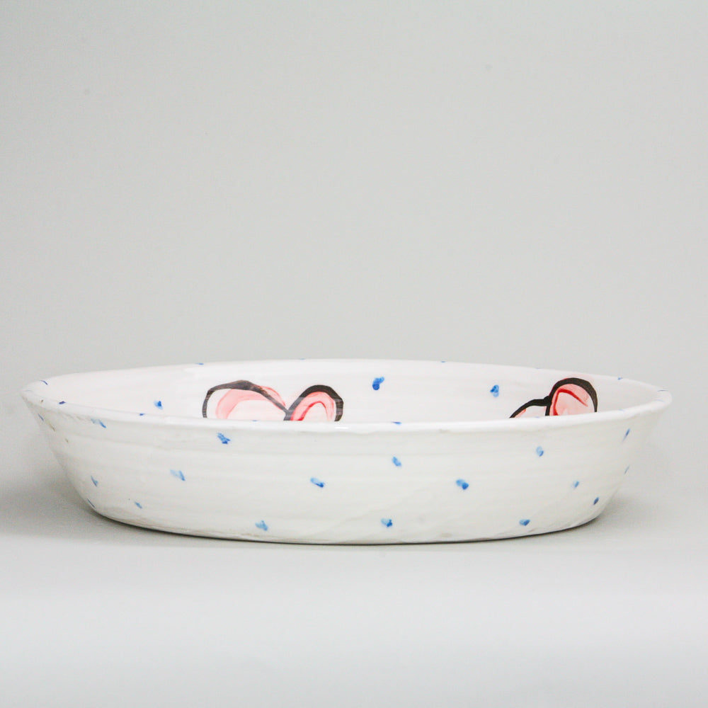 Red hand-painted hearts and little blue dots adorn this large flat heart bowl. Perfect for serving pasta, salad, paella, or a Sunday roast. Handmade in Ireland.