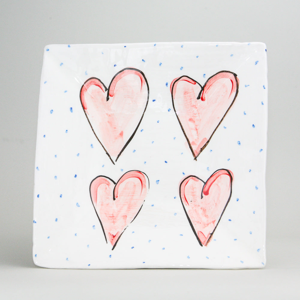 Large square white Irish pottery with a hand-painted red heart with a soft black outline. The ceramics pottery is peppered with little blue dots. Handmade in Ireland.