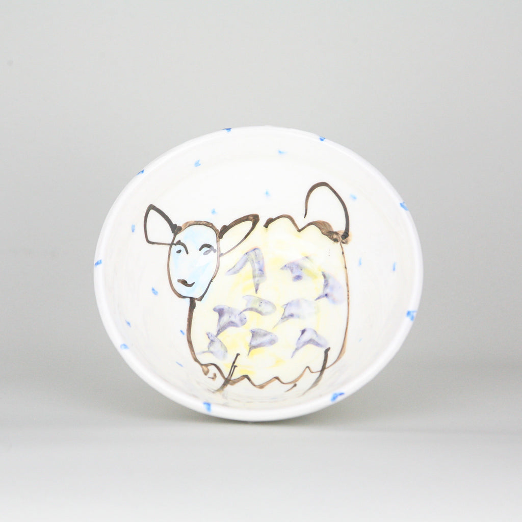 Sheep hand-painted on the inside of a bowl with blue dots peppering the white Irish ceramic pottery. Handmade in Ireland.