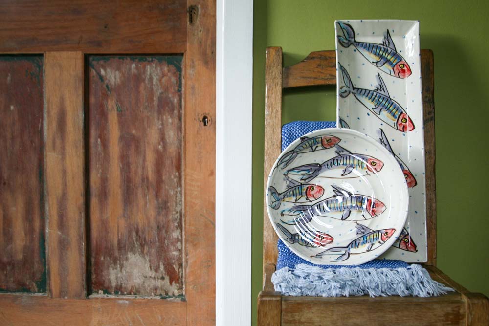 Hand-painted mackerel fish and little blue dots adorn this large flat bowl. Perfect for serving pasta, salad, paella, or a Sunday roast. Behind it leans the large rectangular mackerel platter. Handmade in Ireland.