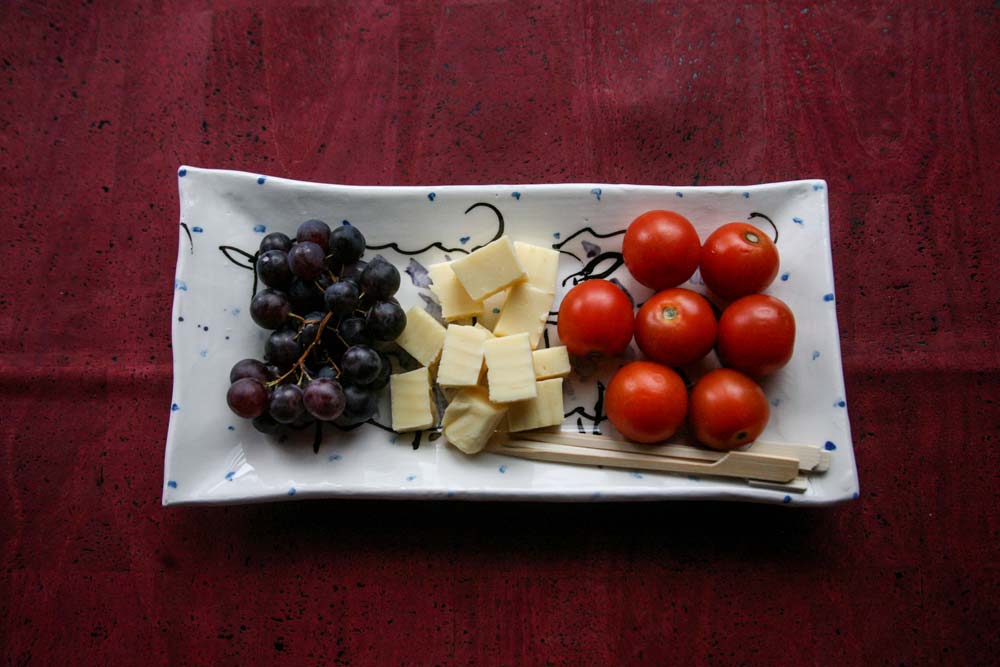 Showing how to use the small sheep rectangular platter with grapes, cheese, and tomatoes.